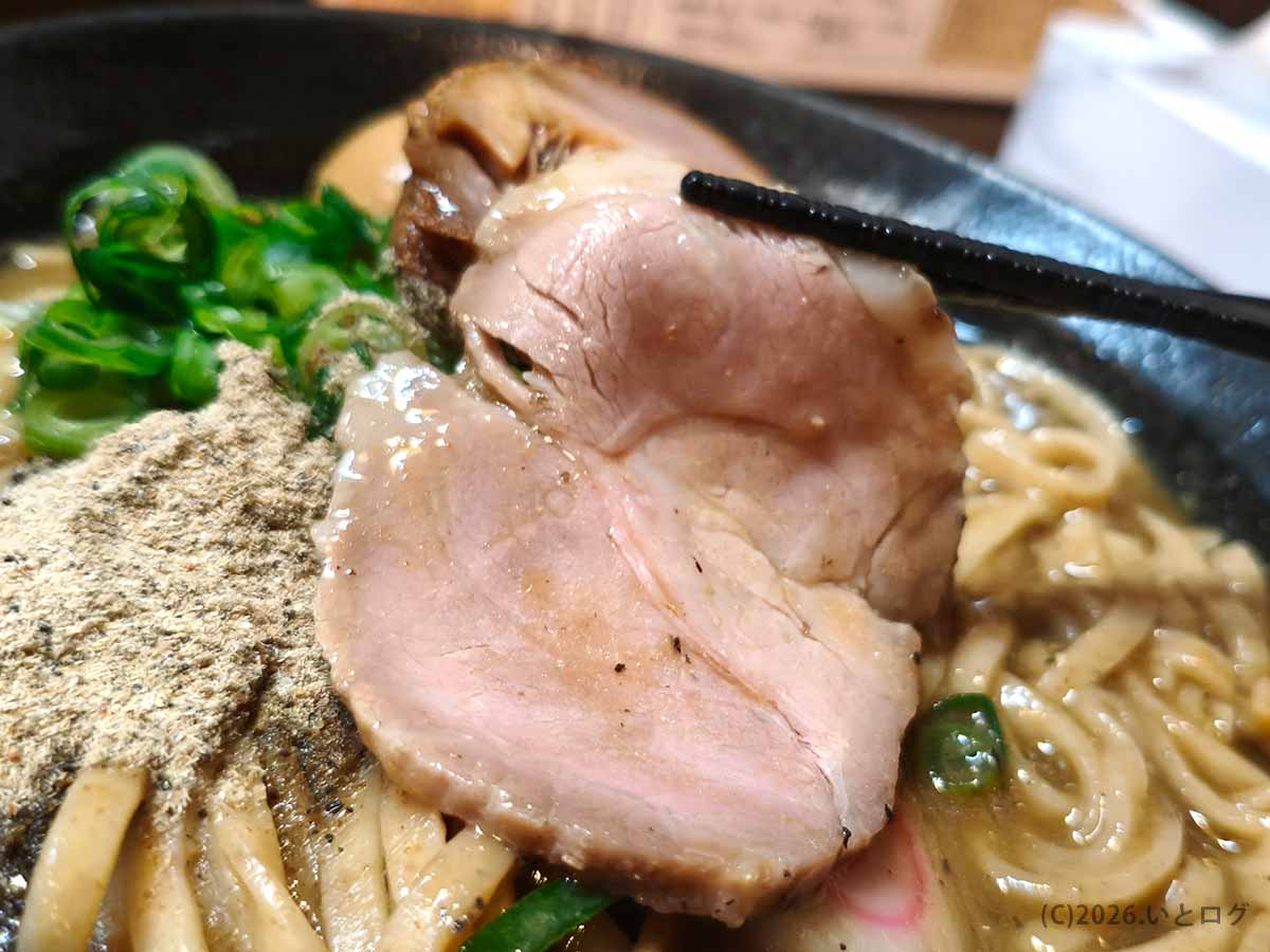 にぼしこいしのラーメンにのる脂身のあるしっとりチャーシューを箸で持ち上げる