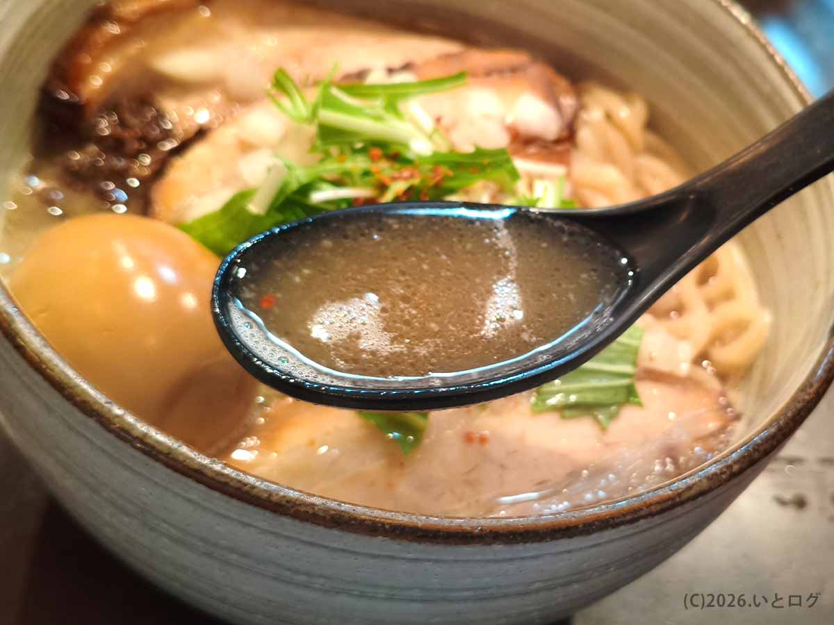 麺処 と市のラーメンスープをレンゲですくった写真。動物系と魚介の旨みが重なるような、濃厚でまろやかなスープ。