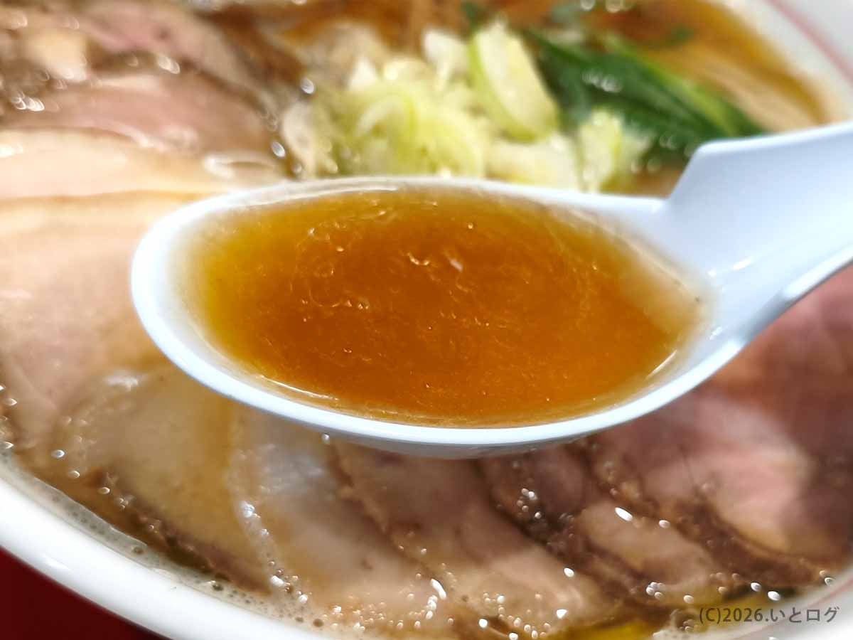 麺屋えぐち奈良のラーメンスープをレンゲですくった様子。透明感のある醤油色のスープに旨味が詰まっている