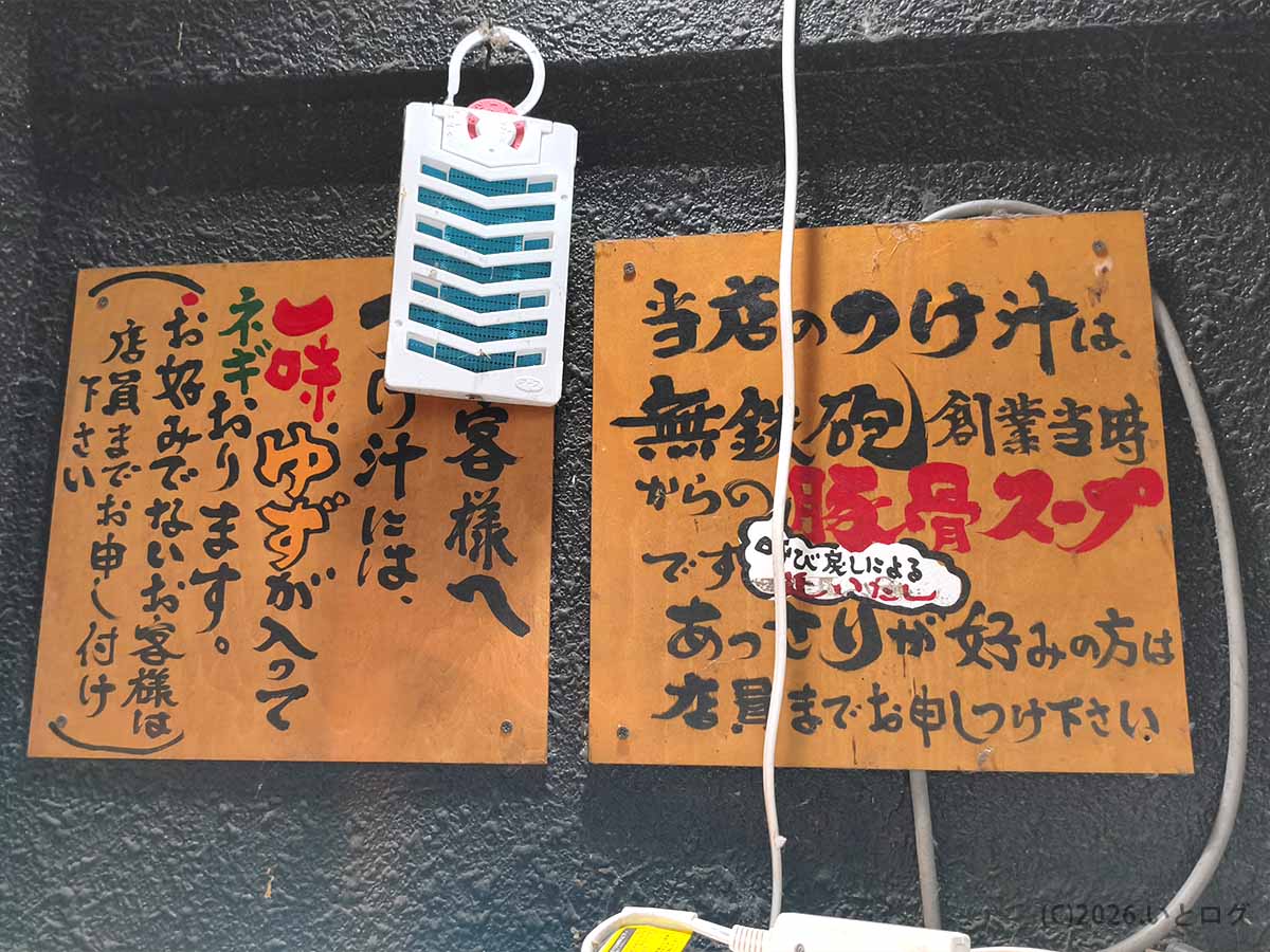 つけ麺 無心の店内に掲示されたゆず入りつけ汁と無鉄砲創業当時の豚骨スープに関する案内板