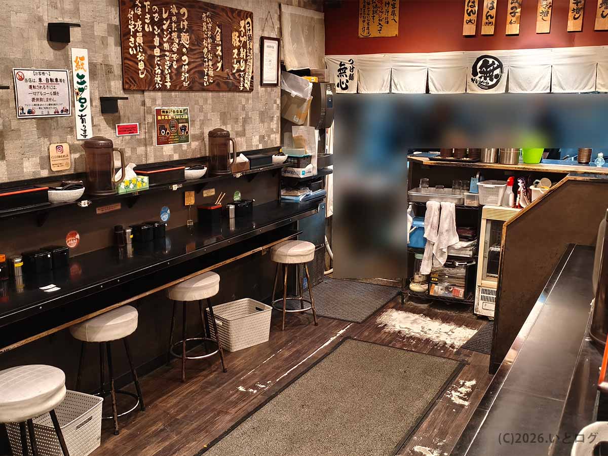 奈良市のつけ麺 無心の店内に並ぶカウンター席と厨房前の様子