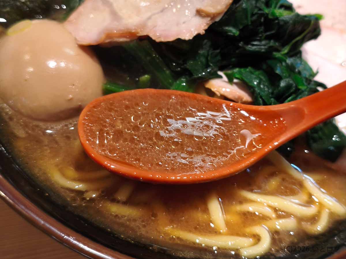 池袋の家系ラーメン店「皇綱家」のスープをレンゲですくった写真。濃厚な豚骨醤油スープに油が浮かび、家系らしい力強さが伝わる。
