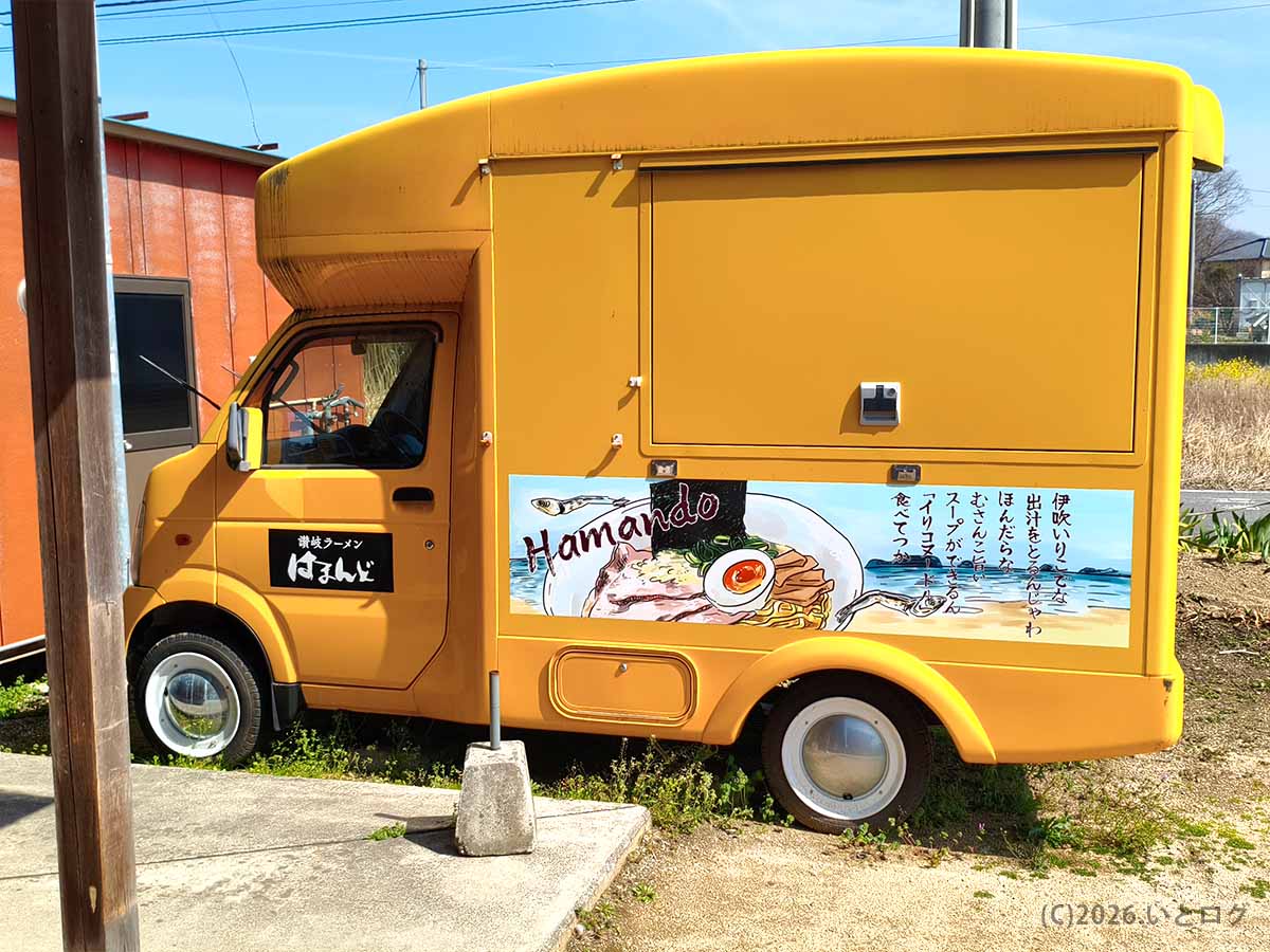香川のラーメン名店・讃岐ラーメン はまんどの黄色いキッチンカー。側面にはラーメンのイラストと「伊吹いりこだよ」などの文字が描かれている。