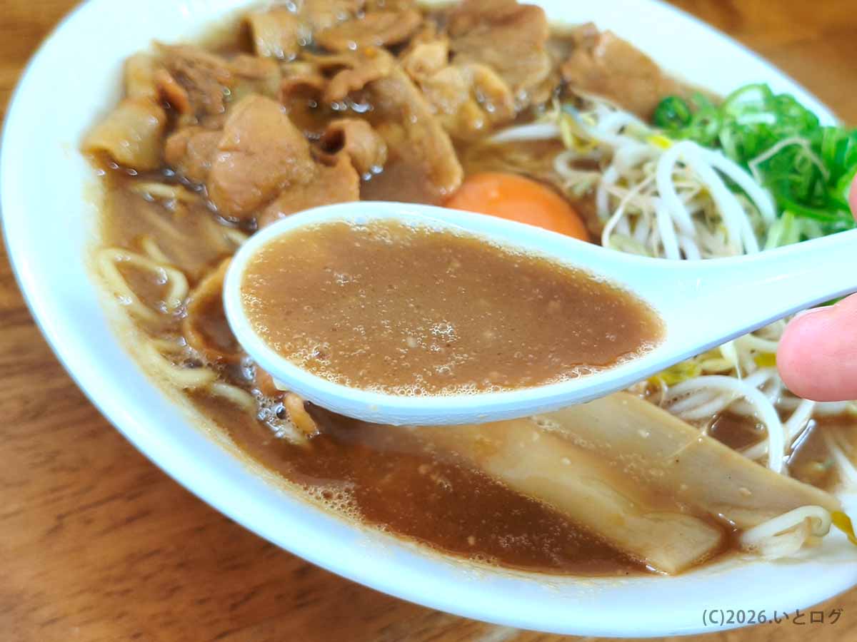 王王軒 本店の徳島ラーメンの茶系スープをレンゲですくった様子