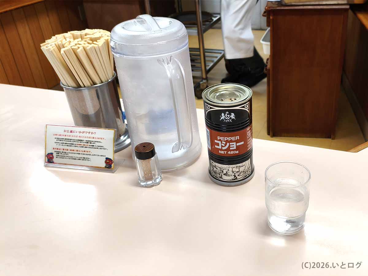 中華そば いのたに 本店の卓上に置かれたコショーや箸、水。徳島ラーメンを好みに合わせて味変しながら楽しめる。