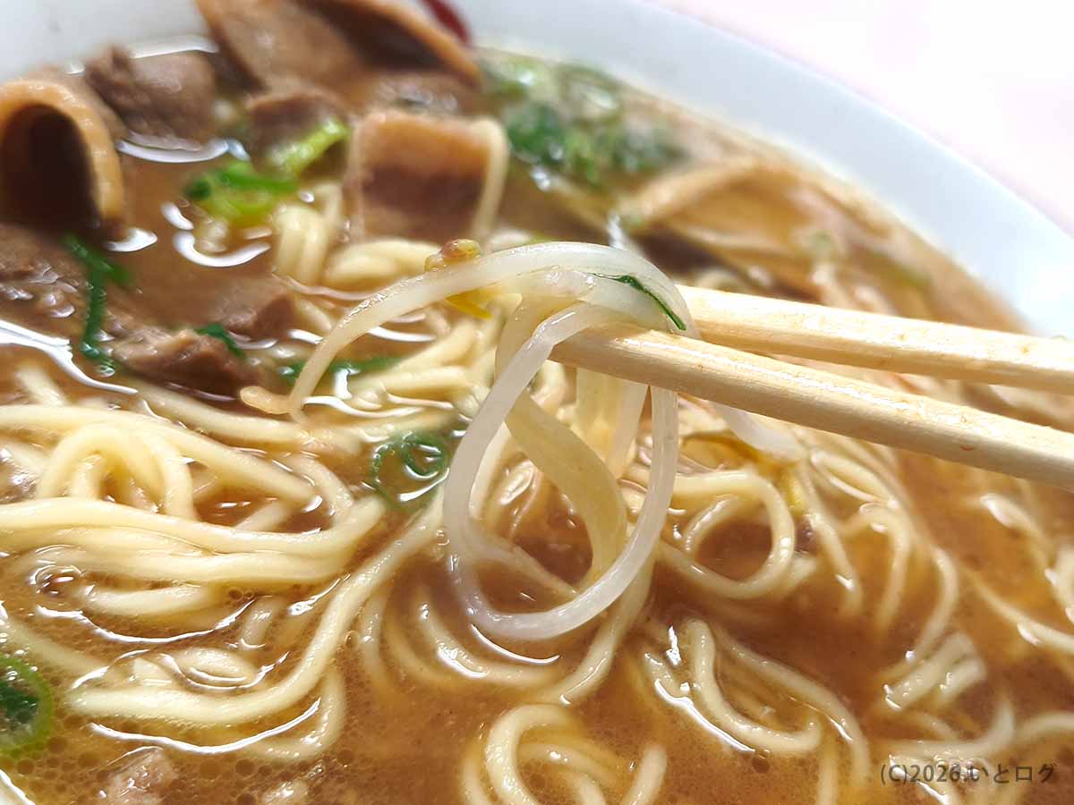 中華そば いのたに 本店の徳島ラーメンに入ったもやしを箸で持ち上げた写真。茶系スープ、麺、肉と合わせて味わえる徳島市のご当地ラーメン。