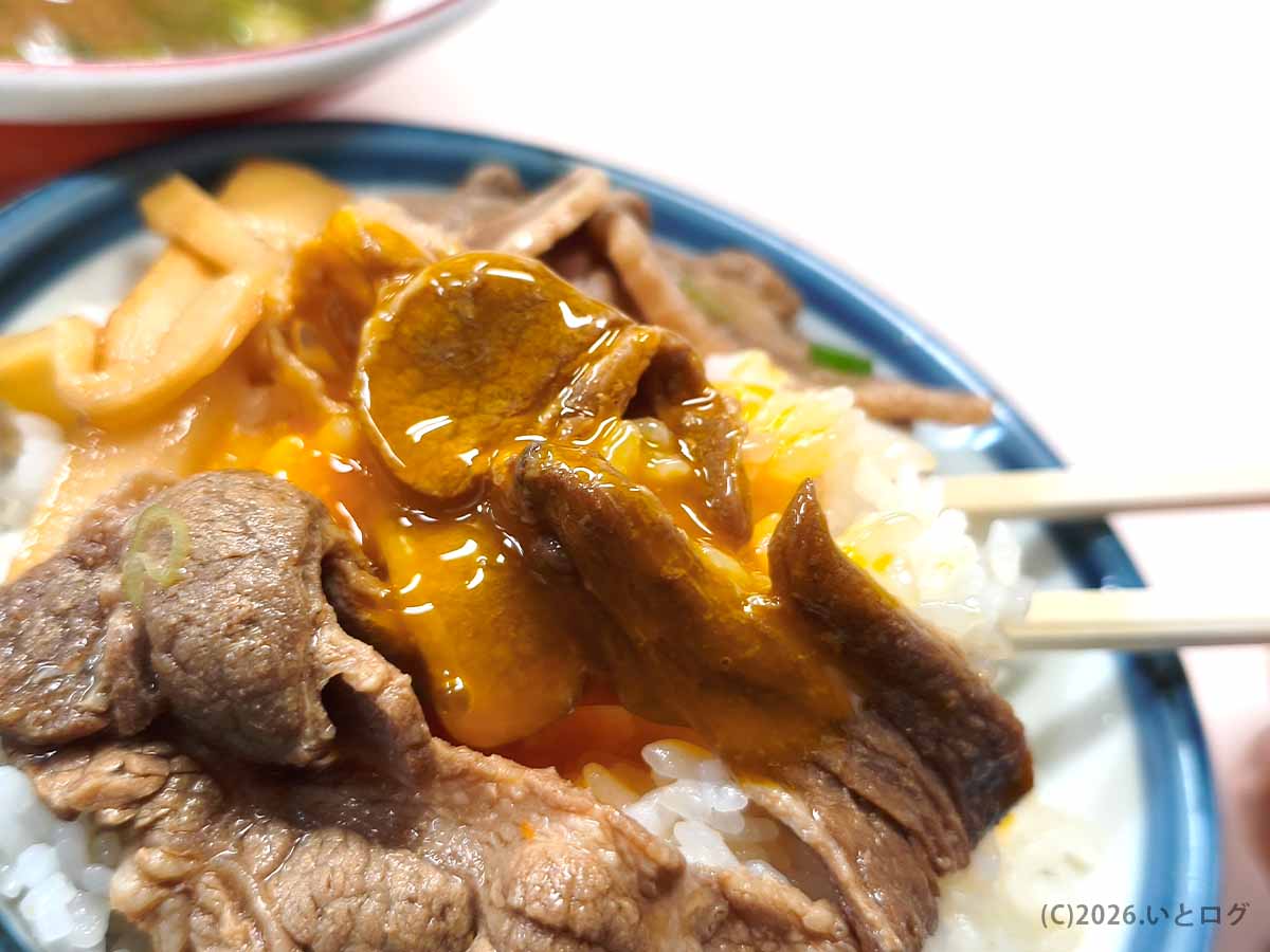 中華そば いのたに 本店の徳島ラーメンの肉と生卵をご飯にのせた写真。甘辛い肉と卵黄がライスに絡み、徳島ラーメンらしい食べ方を楽しめる。
