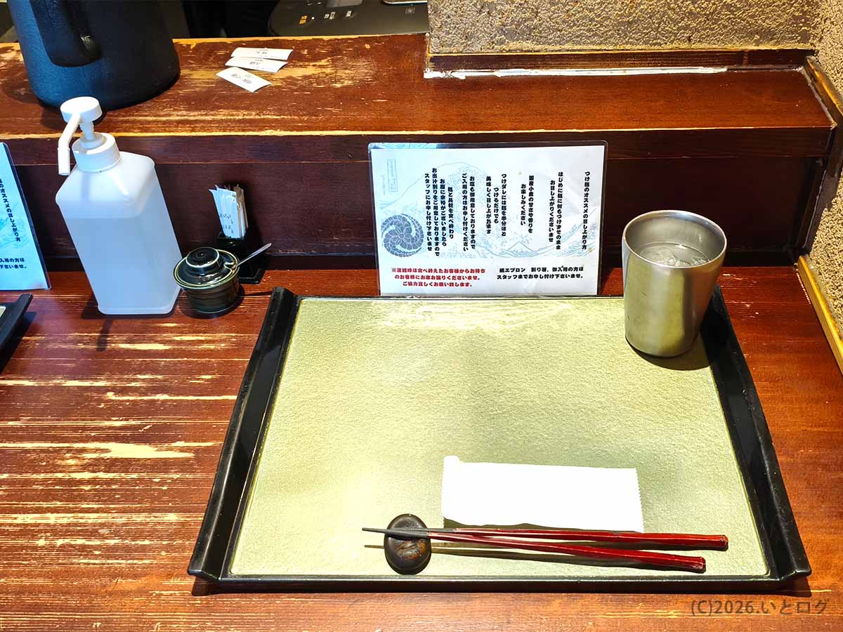 箸と箸置き、金色の配膳トレーが用意された、つけ麺 繁田のカウンター席