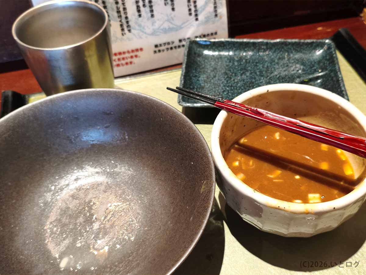 極太麺を食べ終え、濃厚なつけ汁だけが残ったつけ麺 繁田の完食後の器