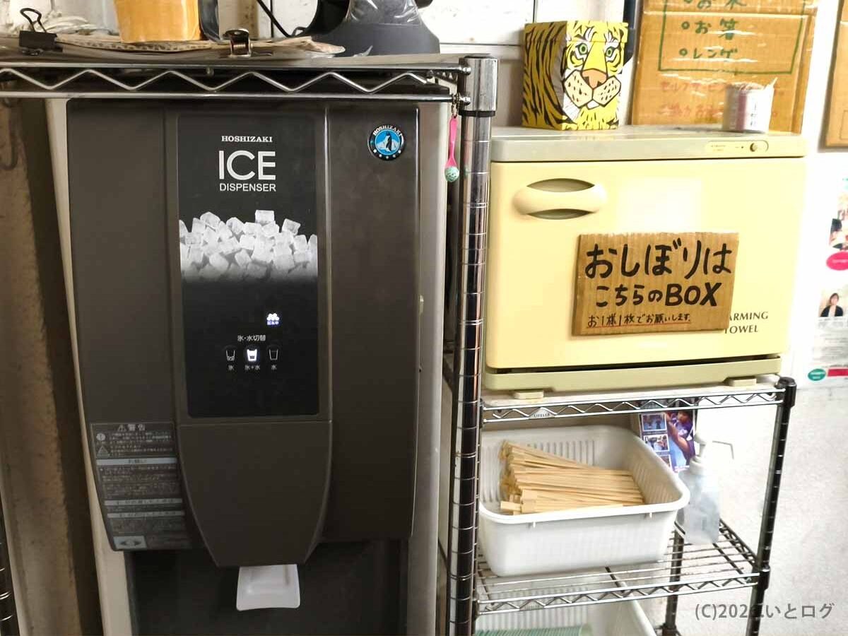 ラーメン荘 歴史を刻め 六甲道の店内に設置された給水機と、セルフサービスのおしぼりBOX