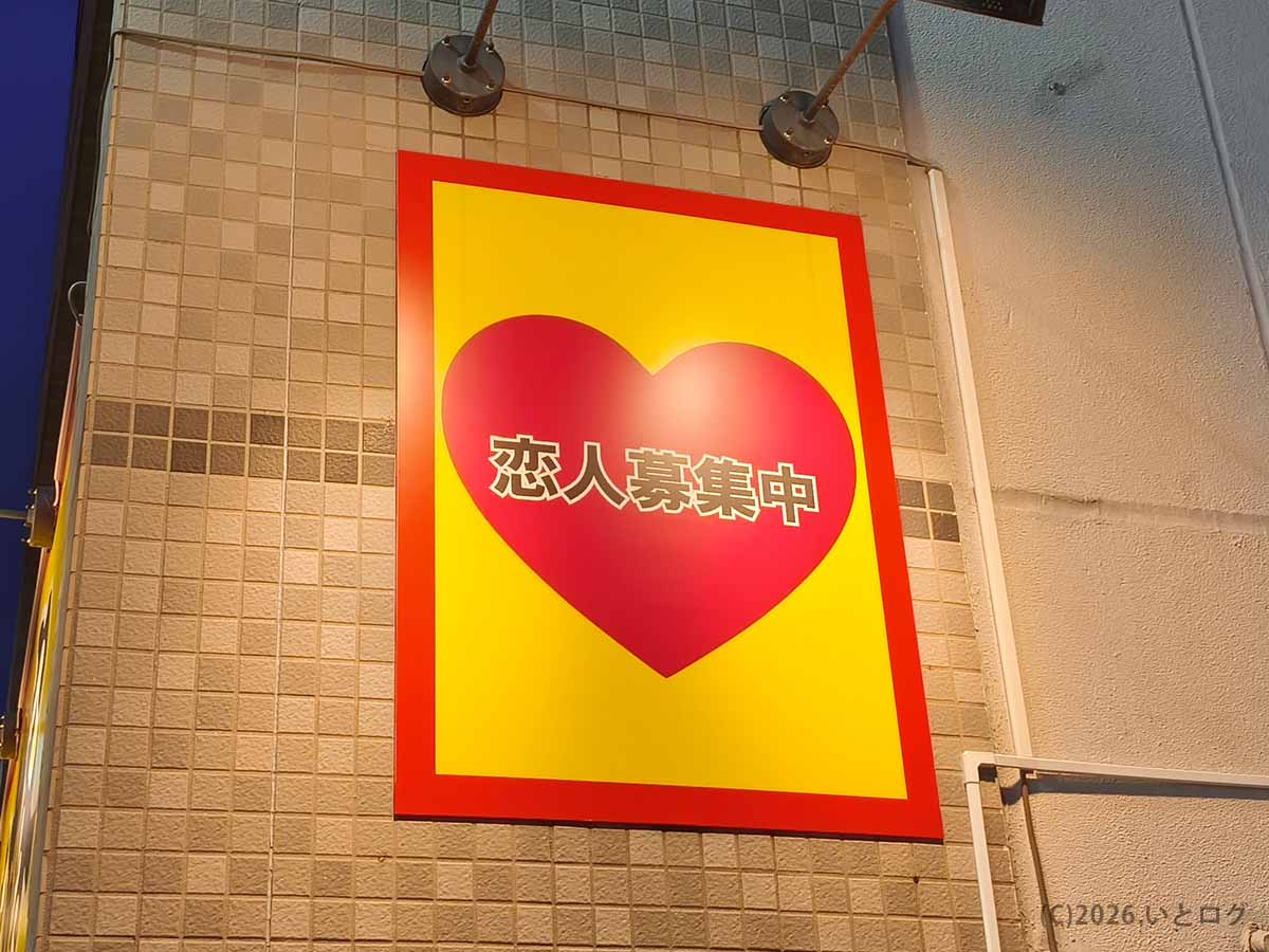 神奈川県平塚市の家系ラーメン店「とらきち家」の外壁に掲げられた、黄色と赤の「恋人募集中」看板
