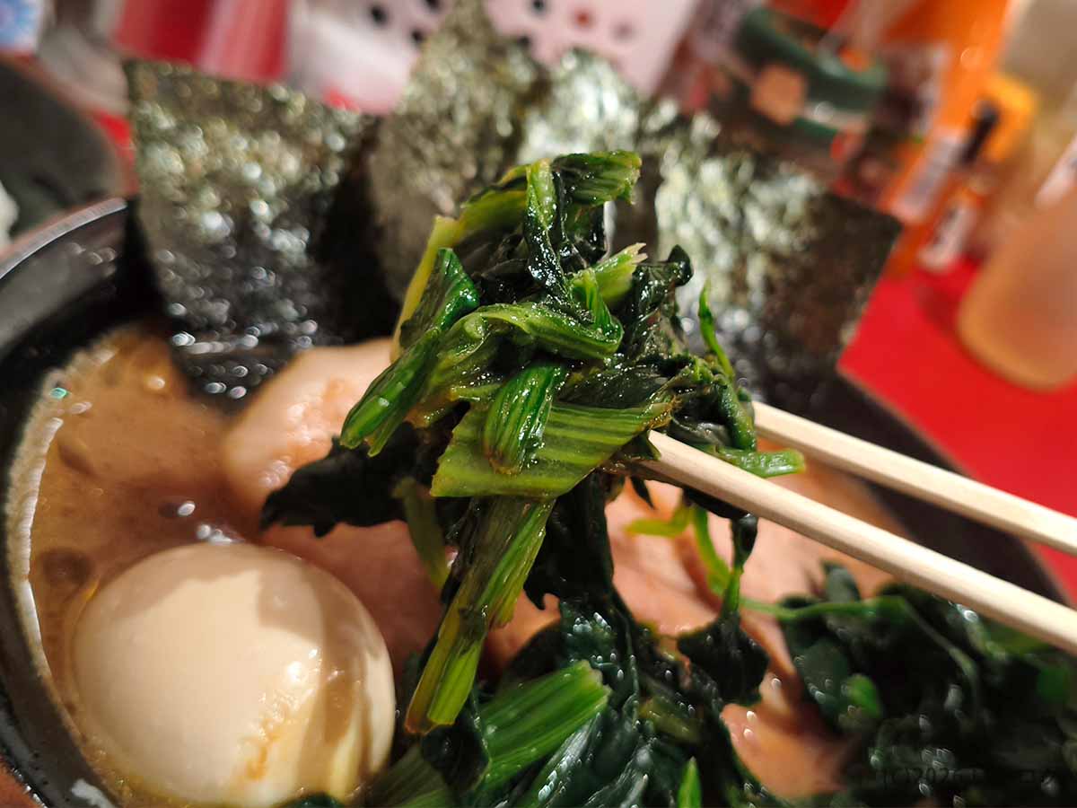 とらきち家の家系ラーメンに盛られた、濃厚な豚骨醤油スープを吸ったほうれん草