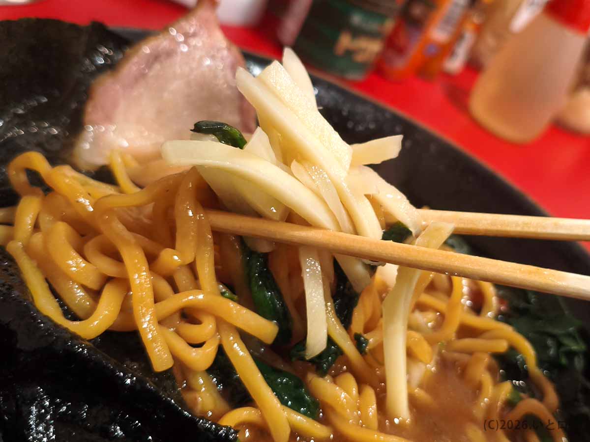 とらきち家の濃厚な家系ラーメンに刻み生姜を加え、後半の味わいをさっぱりと変化させる様子