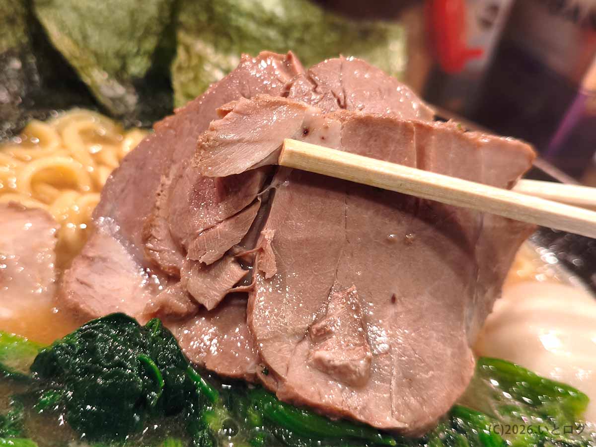 厚木の梅家 舎弟で味わった、しっとりとした質感の大判チャーシューを箸で持ち上げた様子