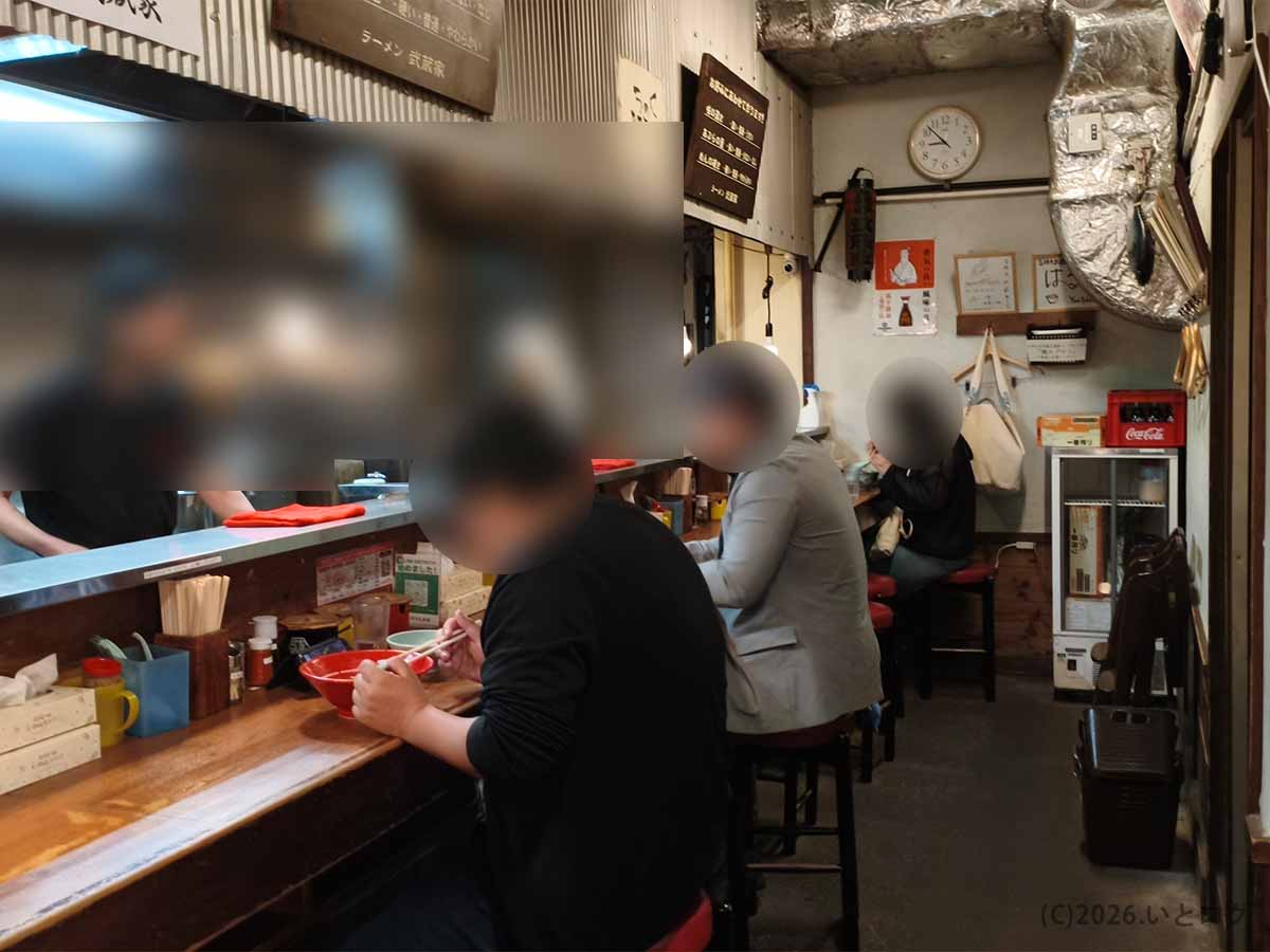 吉祥寺武蔵家 本店の店内。厨房を囲むカウンター席に客が並ぶ、昔ながらの家系ラーメン店らしいコンパクトな空間