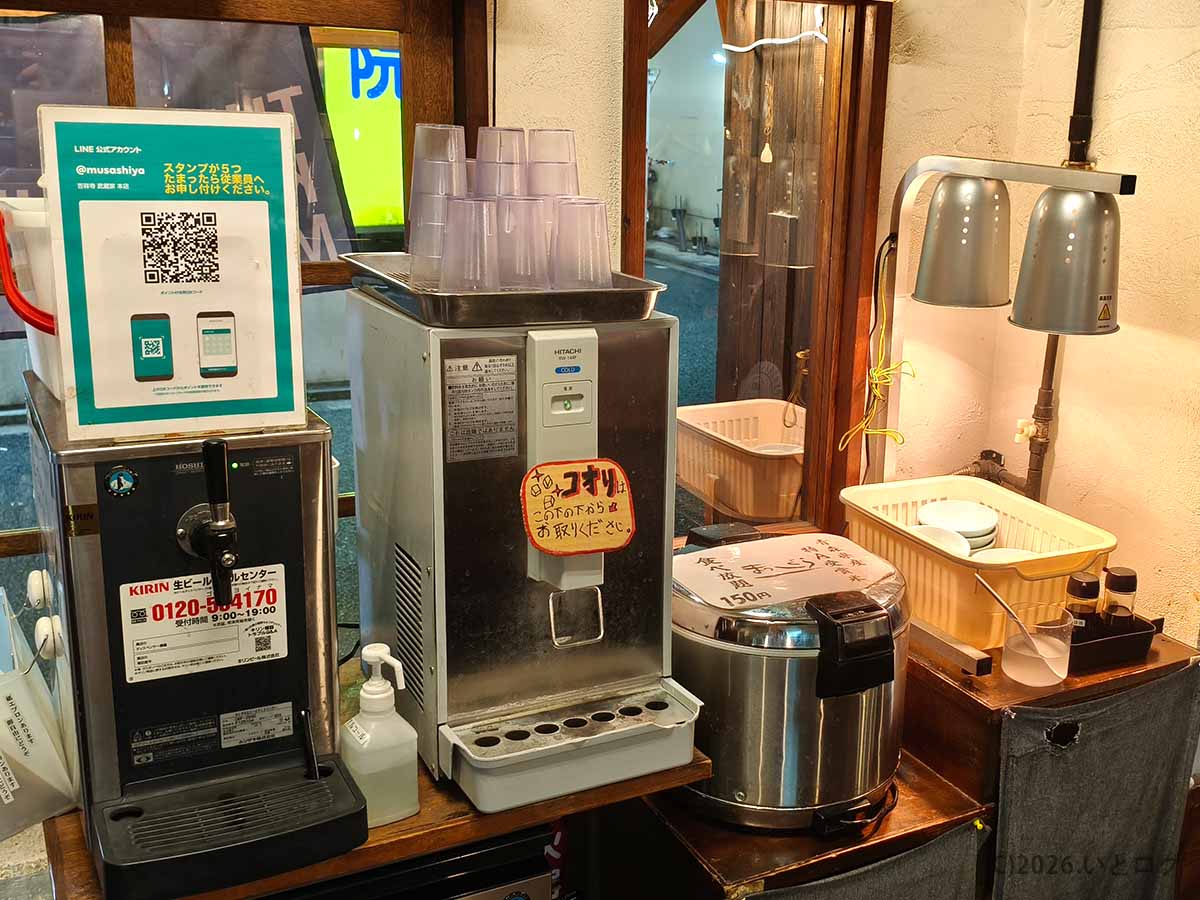 吉祥寺武蔵家 本店の店内に設置されたライス食べ放題コーナー。炊飯器と給水機、使用済みの茶碗を返却するスペースが並ぶ