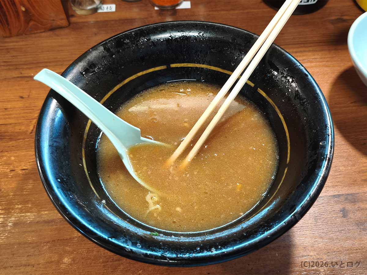 吉祥寺武蔵家 本店のラーメンを食べ終えた後の丼。茶褐色の豚骨醤油スープが残り、レンゲと箸が添えられている