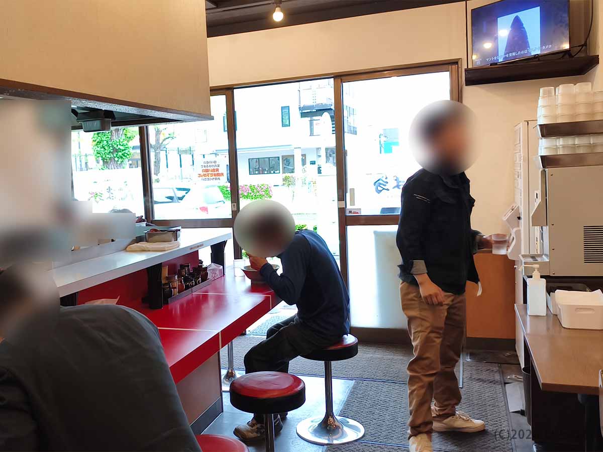 たま家 多摩本店のカウンターに並ぶニンニクや豆板醤などの卓上調味料