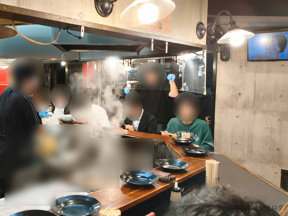 東京・板橋区大山にある自家製麺No11本店の店内。厨房を囲むL字型のカウンター席と、湯気が立ち上る調理風景