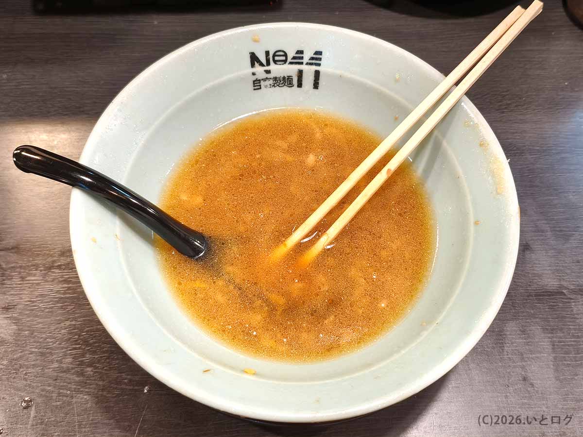 自家製麺ナンバーイレブン大山店のラーメンを食べ終え、スープだけが残った店名ロゴ入りの丼