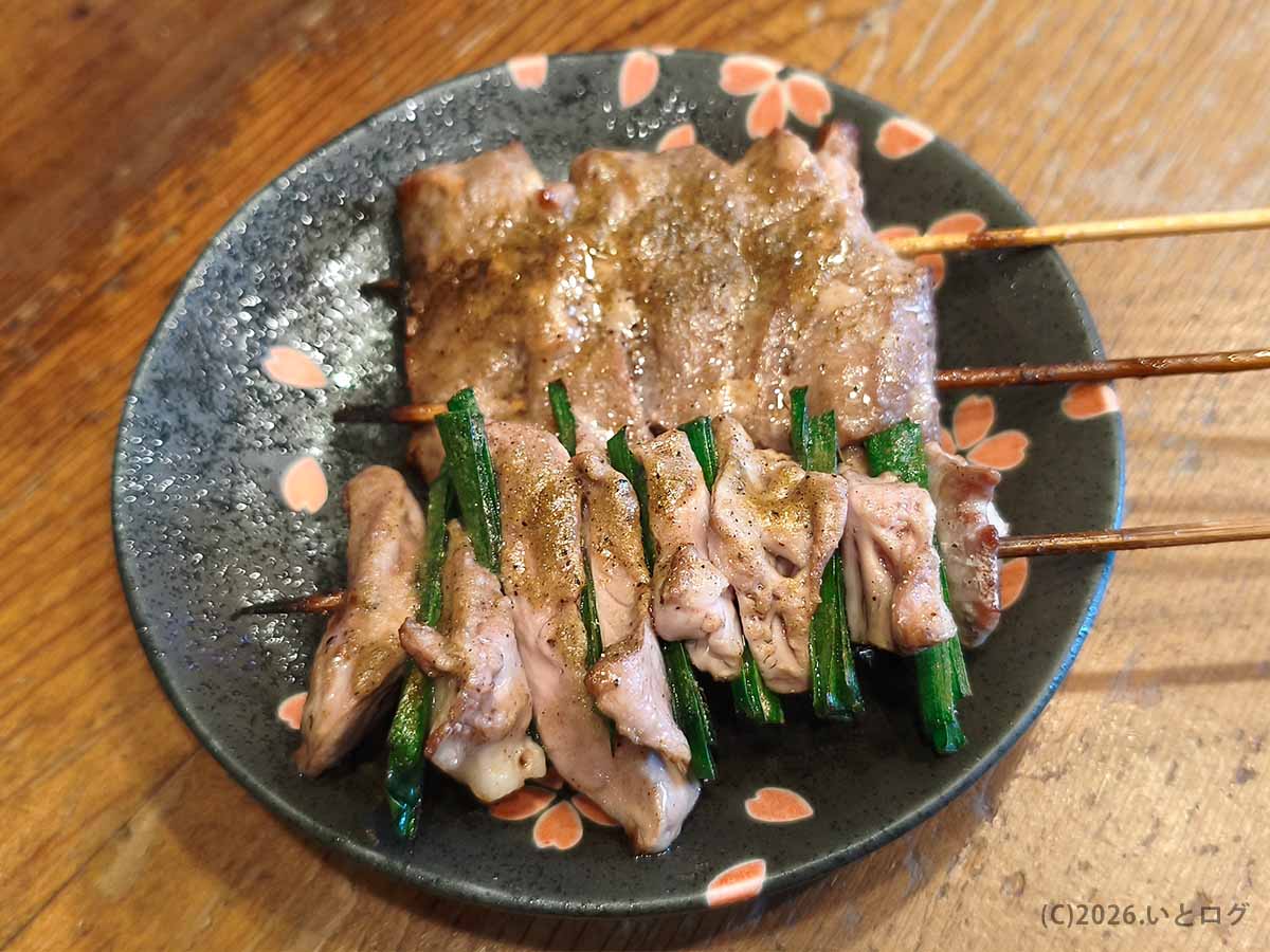 立川のもつ焼き処 美の田で注文した、香ばしく焼かれた串焼きとニラを巻いたもつ串