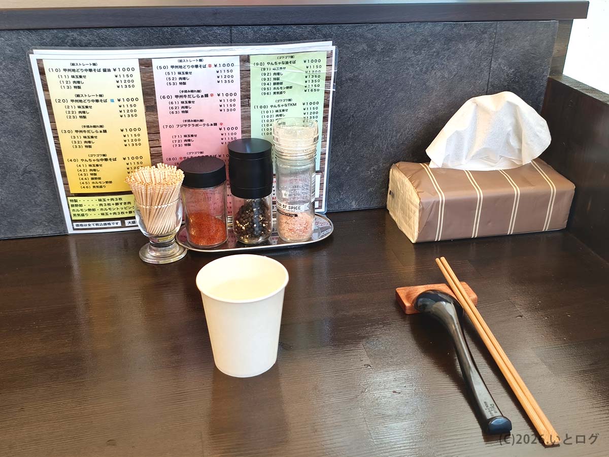 中華そば 蘭 甲府の卓上調味料とカウンター席。落ち着いて山梨ランチを楽しめる空間