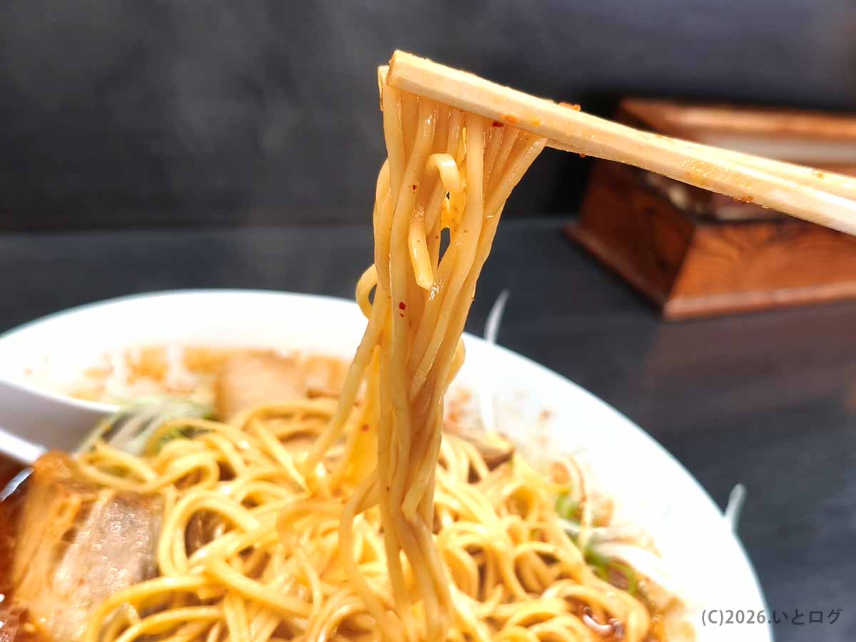 宮崎市清武の竜宮ラーメンで提供される激辛ねぎみそラーメンの麺を箸で持ち上げた様子