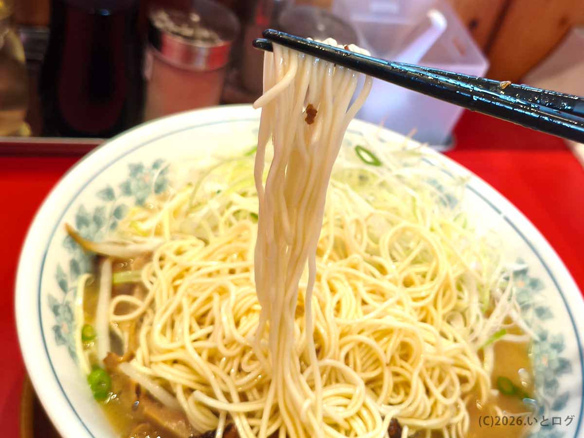 都城の豚骨ラーメン店いってつの細麺を箸で持ち上げた様子。豚骨スープに合わせたストレート麺