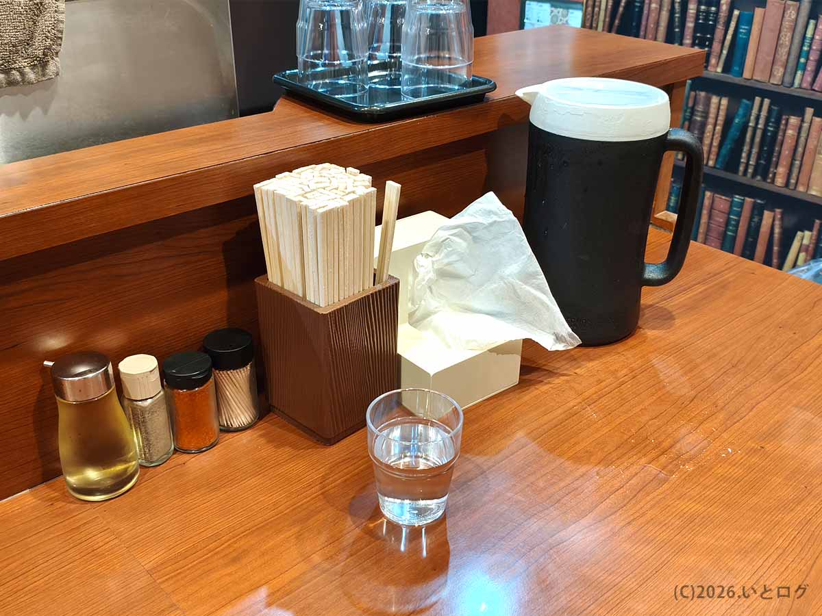 東京らぁめん 西橘店のカウンターに用意された調味料や箸、水