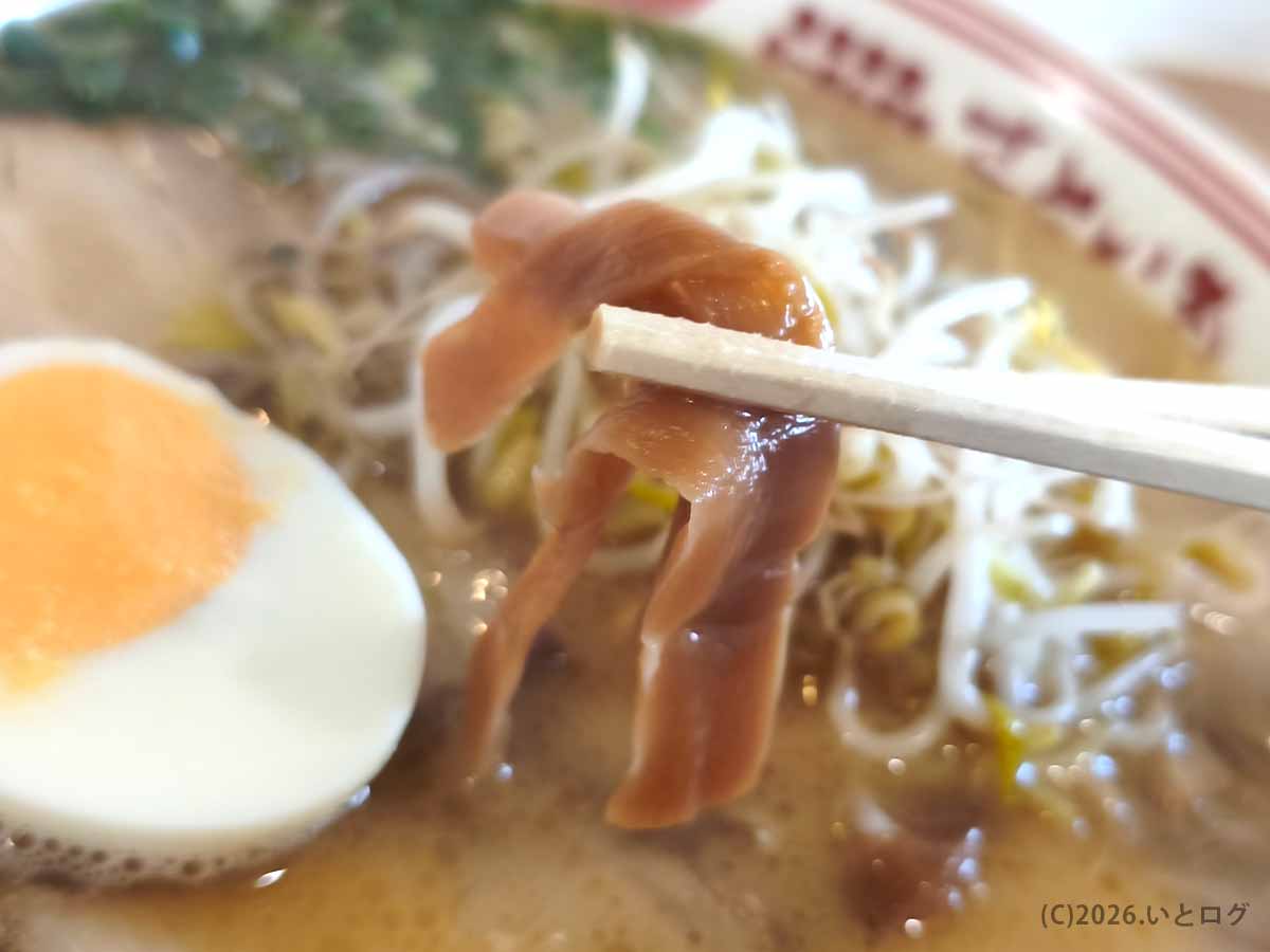 宮崎市のらーめん本舗 さといも 本店のラーメンに入った、細長いメンマを箸で持ち上げた様子