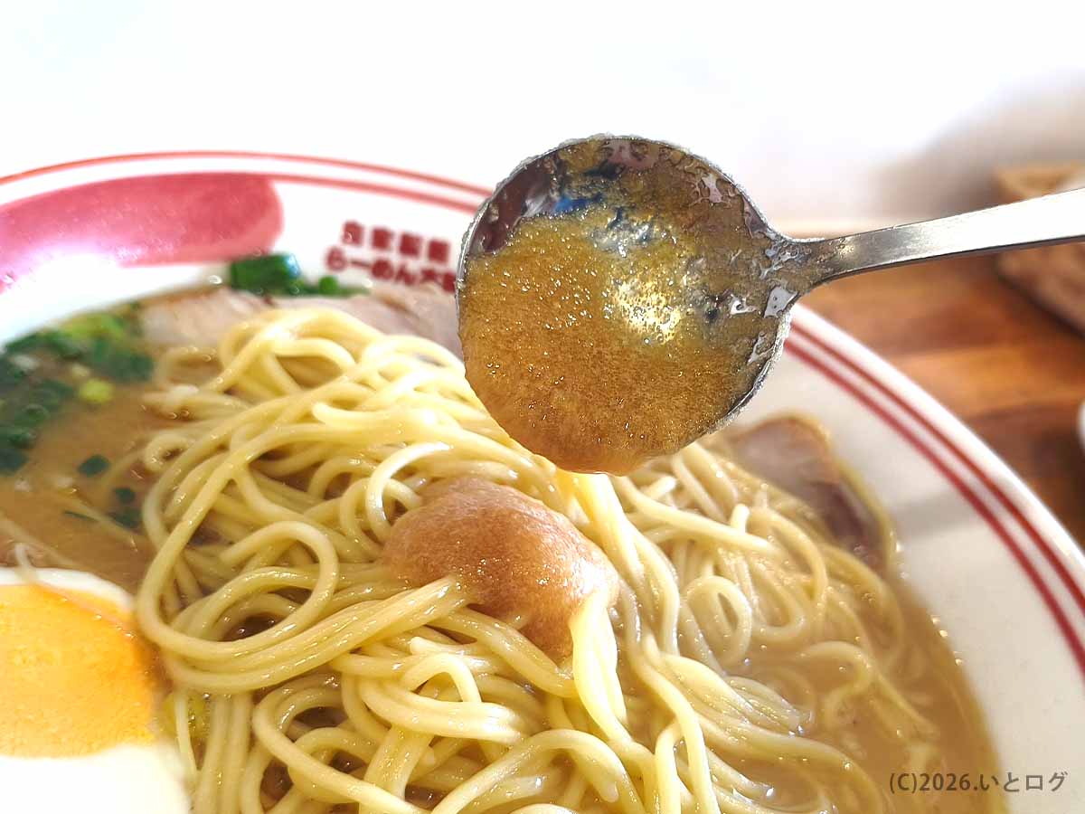 らーめん本舗 さといも 本店のラーメンに卓上調味料を加えて味の変化を楽しむ様子