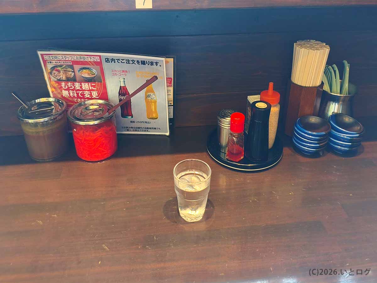 風来軒 加納本店のカウンターに置かれた卓上調味料。紅しょうがやラーメンダレ、ゴマなどが用意されている