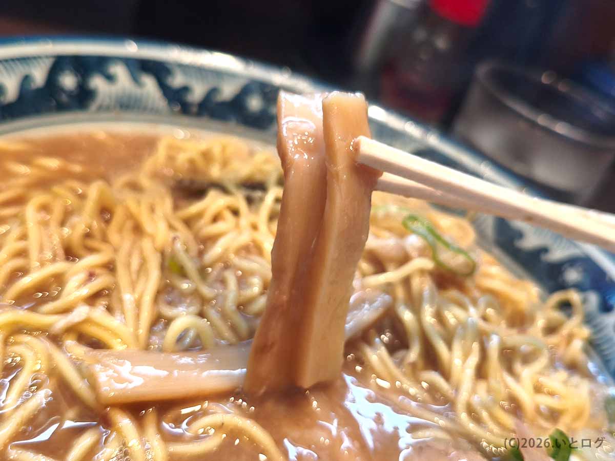 風来軒 加納本店のとんこつラーメンに入ったメンマ。濃厚な宮崎豚骨スープをまとった太めのメンマを箸で持ち上げる