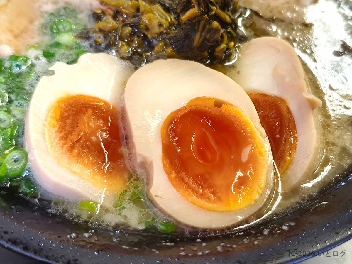 月乃家のラーメンにトッピングされた、とろりと濃厚な黄身が美しい味付け玉子（味玉）のアップ。