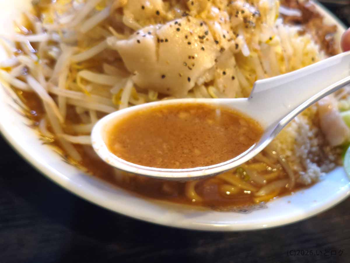 長野県松本市の二郎系ラーメン店「麺とび六方 松本本店」のラーメン。れんげですくった豚骨味噌スープのアップ。
