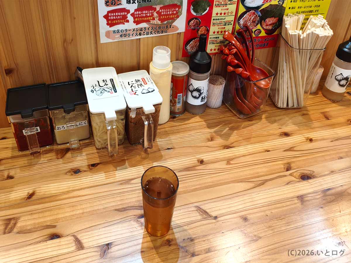 富山家の卓上調味料。刻みしょうが、無限にんにく、酢、マヨネーズなどが並び、家系ラーメンやライスの味変を楽しめる。