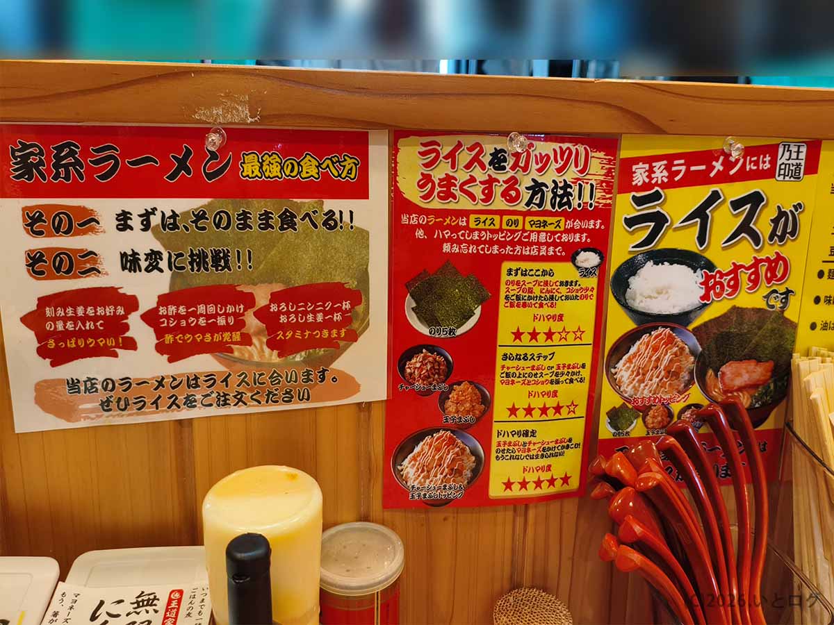 富山家の店内に貼られた家系ラーメンの食べ方とライスアレンジの案内。ライスに合う食べ方や卓上調味料の使い方が紹介されている。