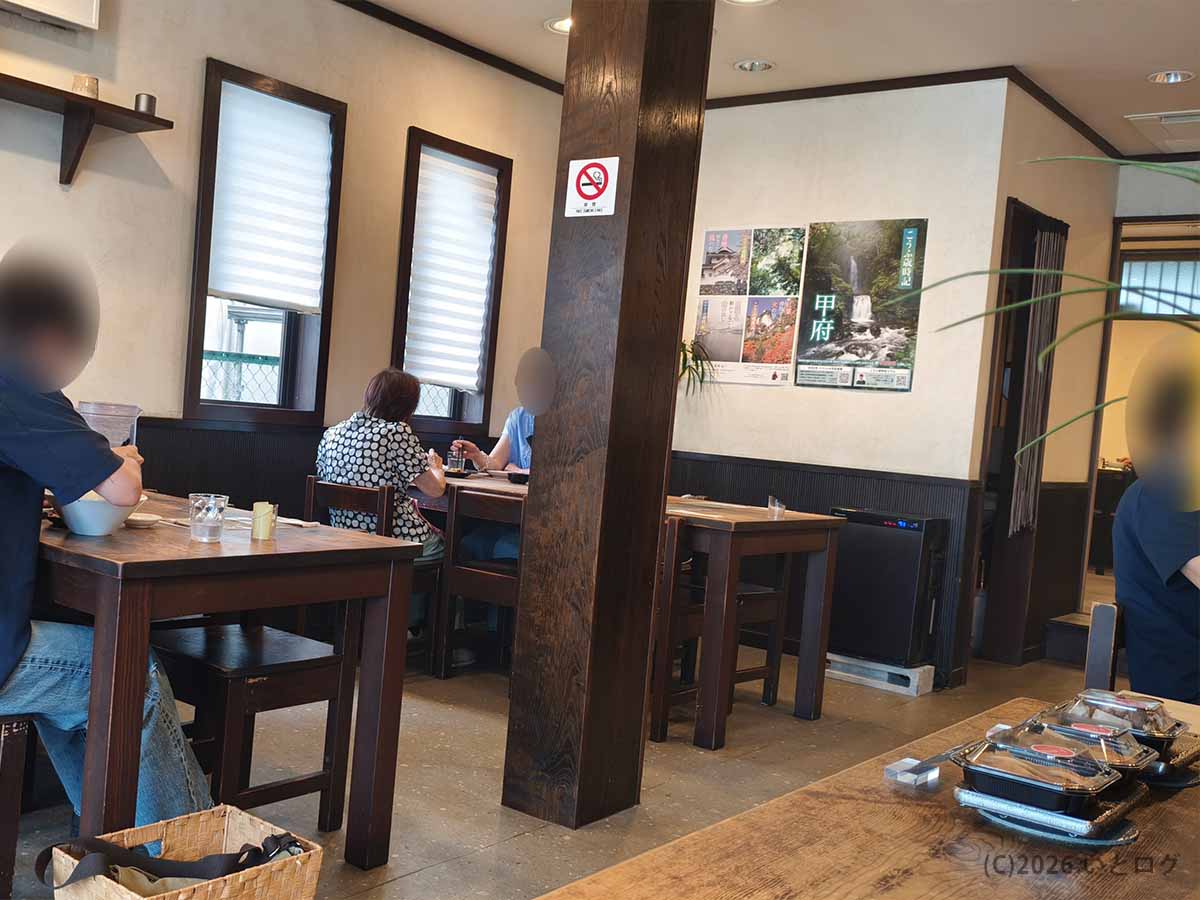 木製のテーブル席が並ぶ、甲府市の老舗ラーメン店「上田屋」の落ち着いた店内