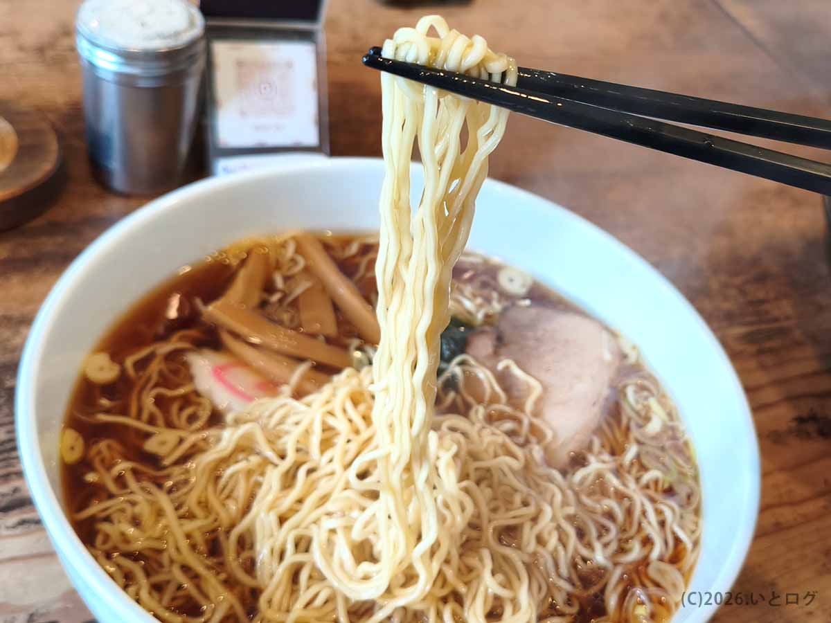 上田屋の醤油ラーメンから、細く縮れた中華麺を箸で持ち上げた様子