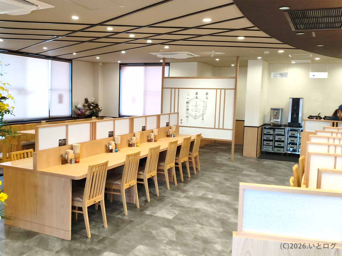 山梨県甲斐市の初志貫徹 甲斐竜王店に設けられた、木目調のカウンター席とテーブル席が並ぶ明るい店内