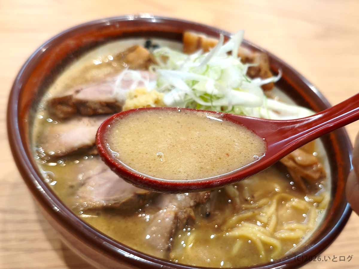 初志貫徹 甲斐竜王店のチャーシューみそから、香ばしく濃厚な味噌スープをレンゲですくった様子