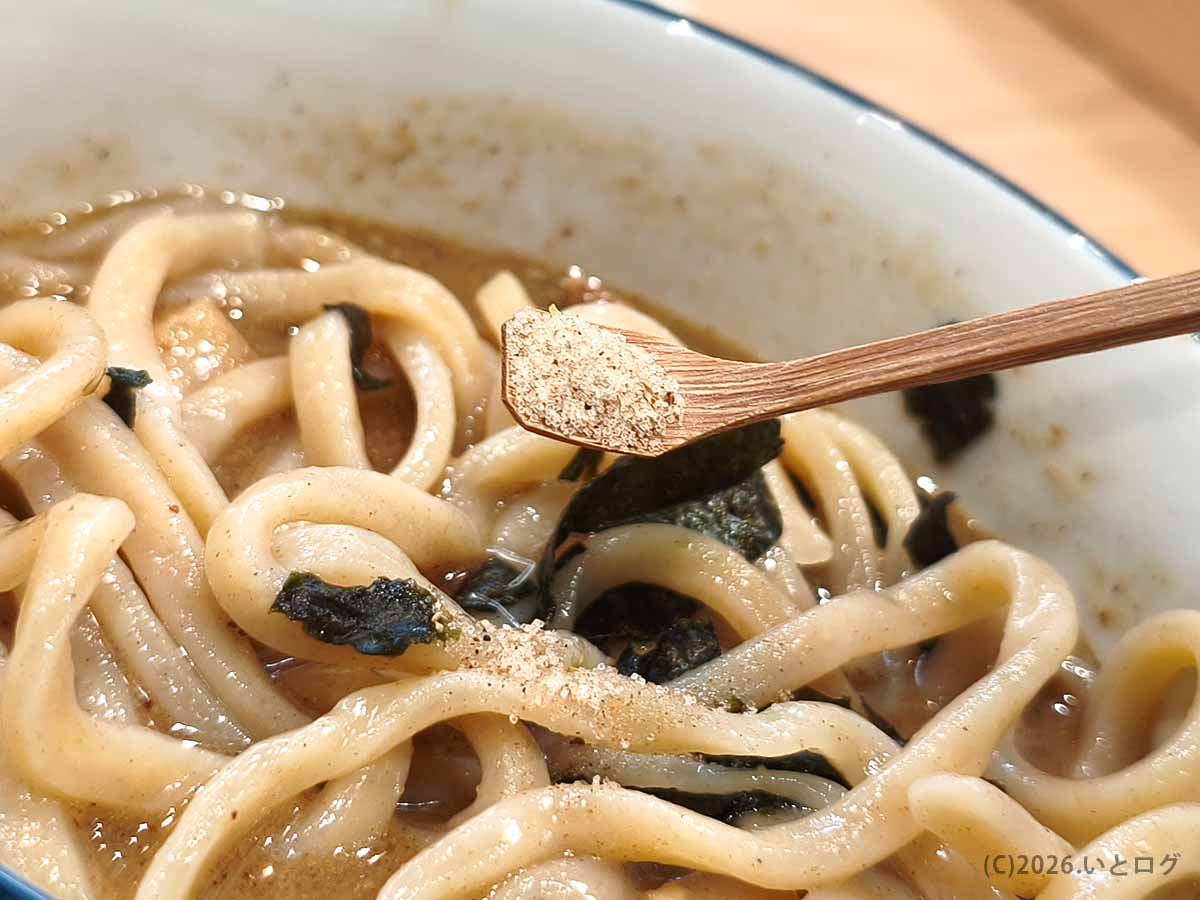 初志貫徹 甲斐竜王店の味噌つけ麺に、付属の山椒塩を振りかけて味の変化を楽しむ様子