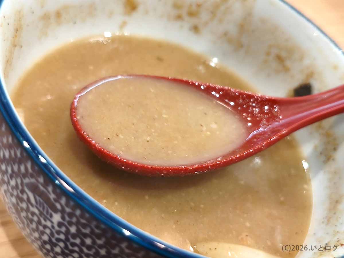 初志貫徹 甲斐竜王店の味噌つけ麺を食べたあと、スープ割りを加えてまろやかになったつけ汁をレンゲですくった様子