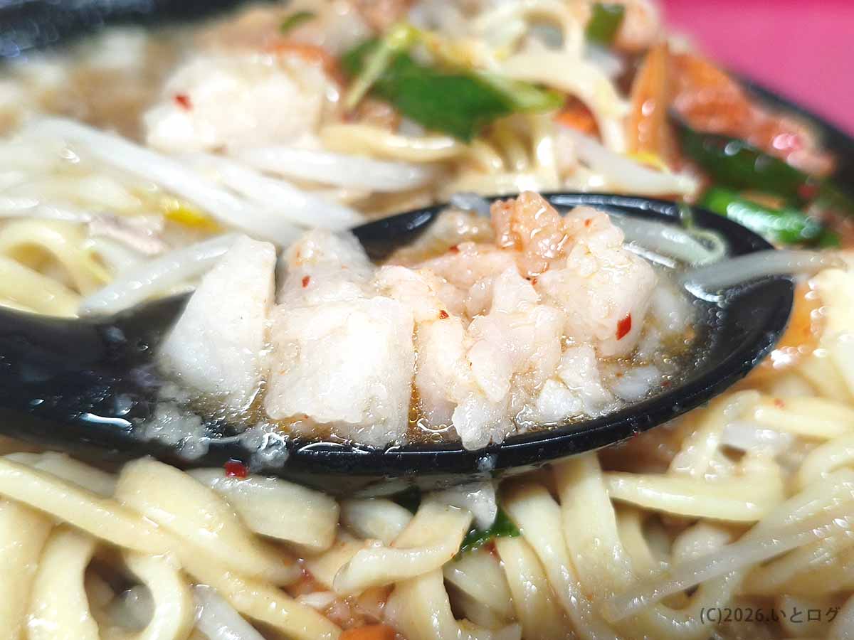 ラーメン二郎 新潟店の背脂を黒いレンゲですくった写真。大きめの白い脂の塊がスープに浸っている。