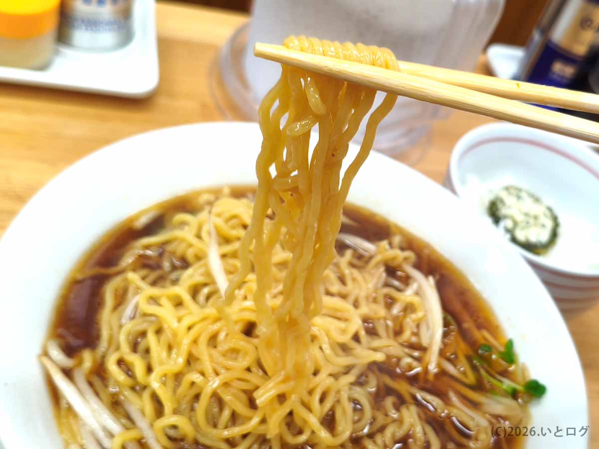 帯広のラーメンみすゞで食べた黄色い縮れ麺。箸で持ち上げた麺が醤油色のスープをまとい、丼にはもやしや野菜が入っている