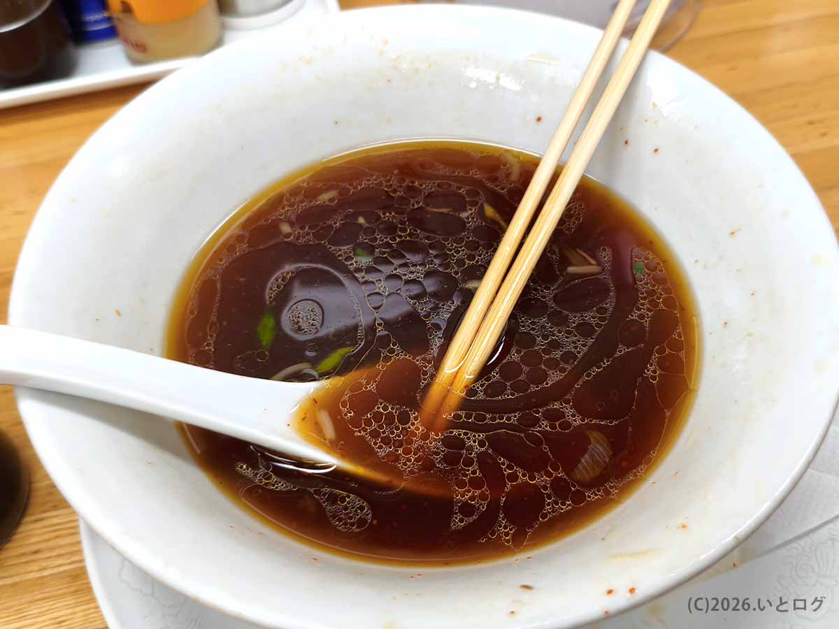 帯広のラーメンみすゞで食べたラーメンの食後の丼。醤油色のスープに細かな油滴が浮かび、レンゲと箸が添えられている