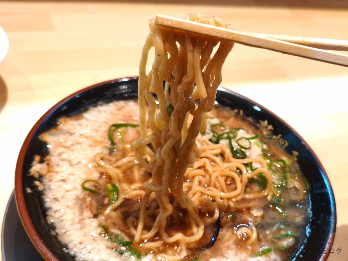 あなたの心を鷲掴み ほぼ博多本店の濃厚豚骨スープをまとった麺を持ち上げた様子