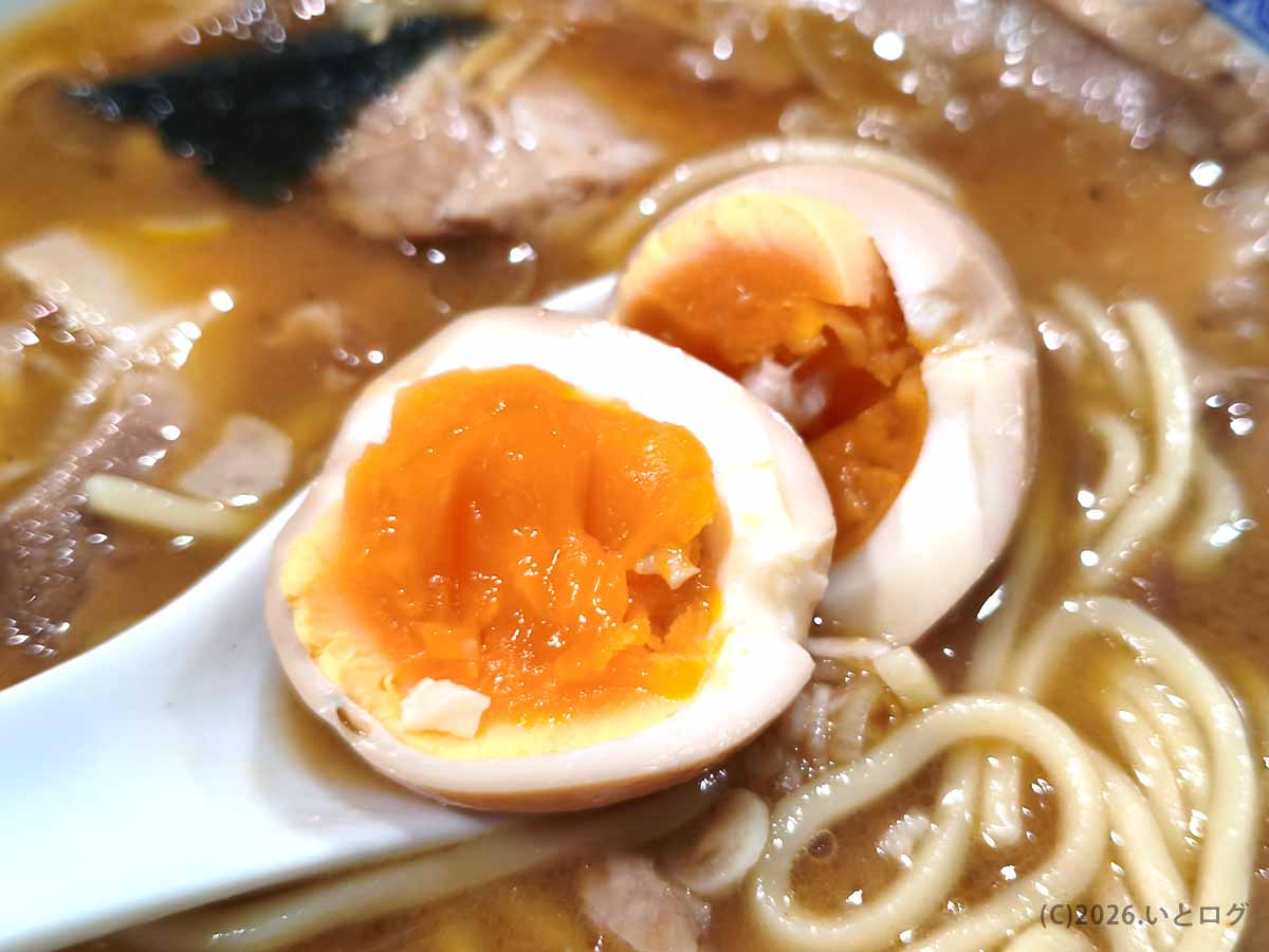 べんてん成増のラーメンに追加した味付玉子の断面。半分に切った玉子のオレンジ色の黄身と味の染みた白身