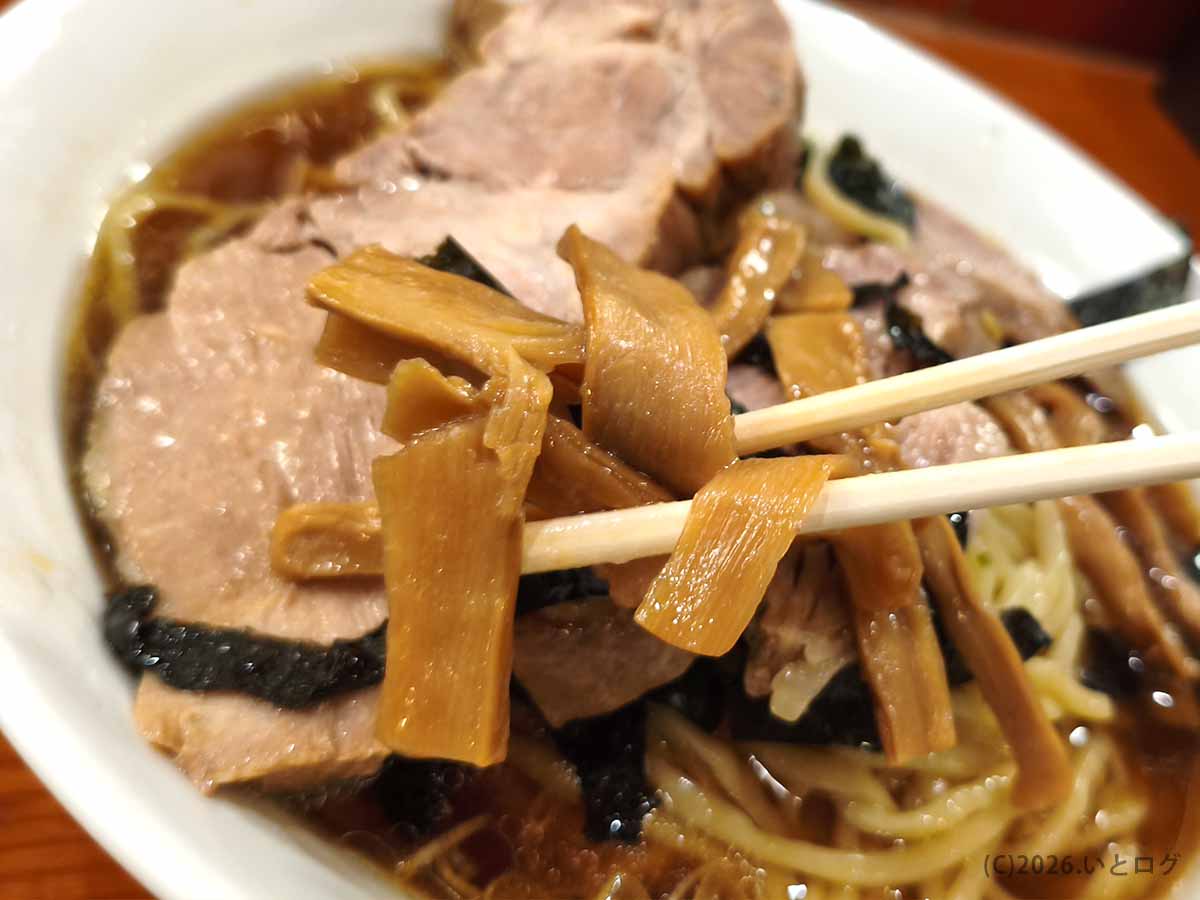 新宿のらあめん満来で食べたチャーシューらあめんのメンマ。醤油色に染まった太めのメンマを箸で持ち上げた様子
