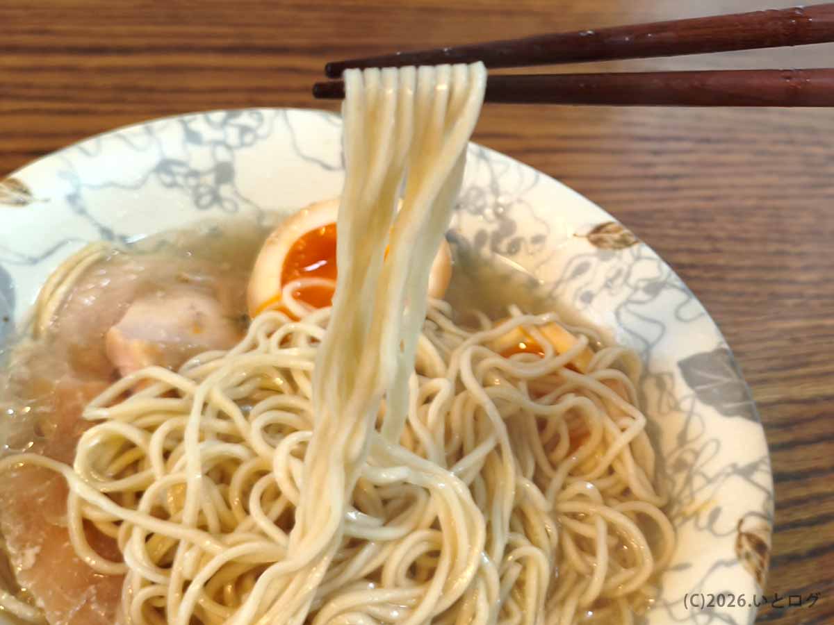 富士吉田の「とりそば ささ」で提供される、とりそば塩の中細ストレート麺を箸で持ち上げた様子